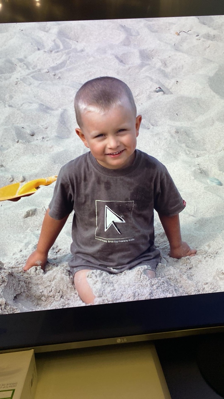 Krystian as a small child on a beach