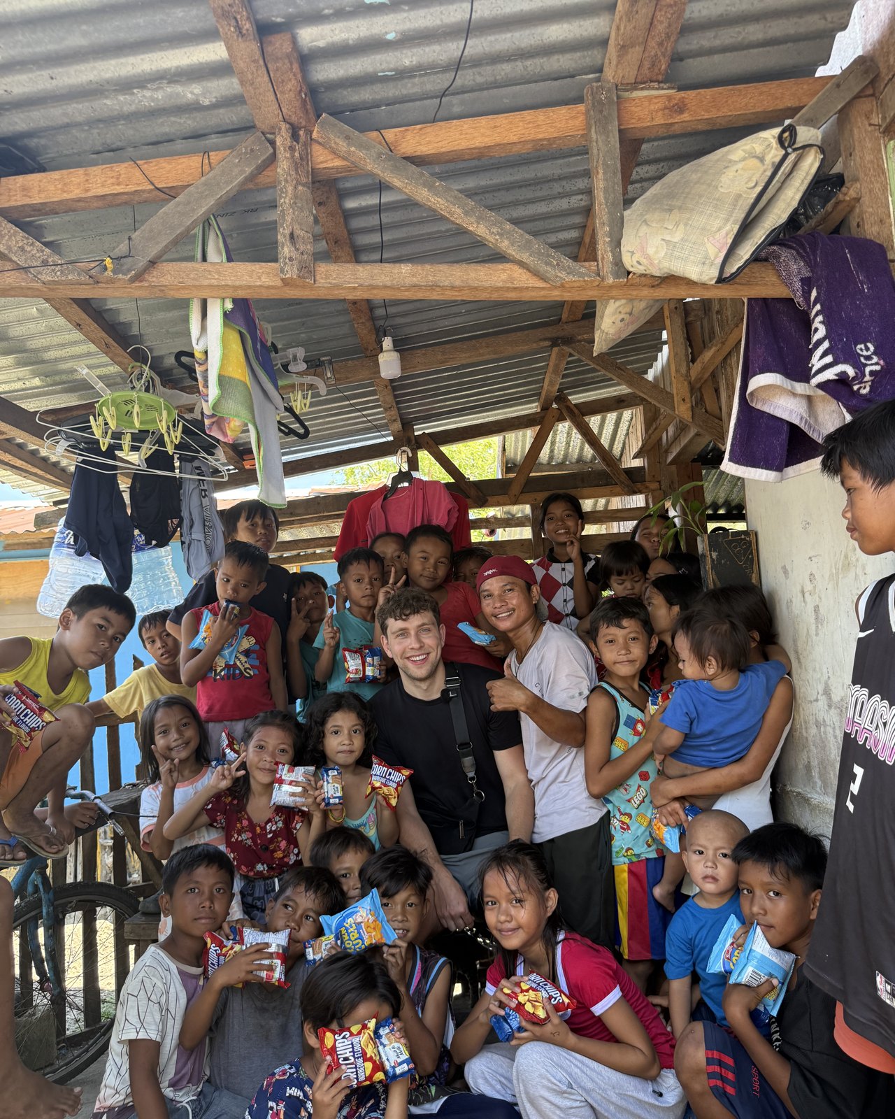 Krystian with a large group of children in the Philippines